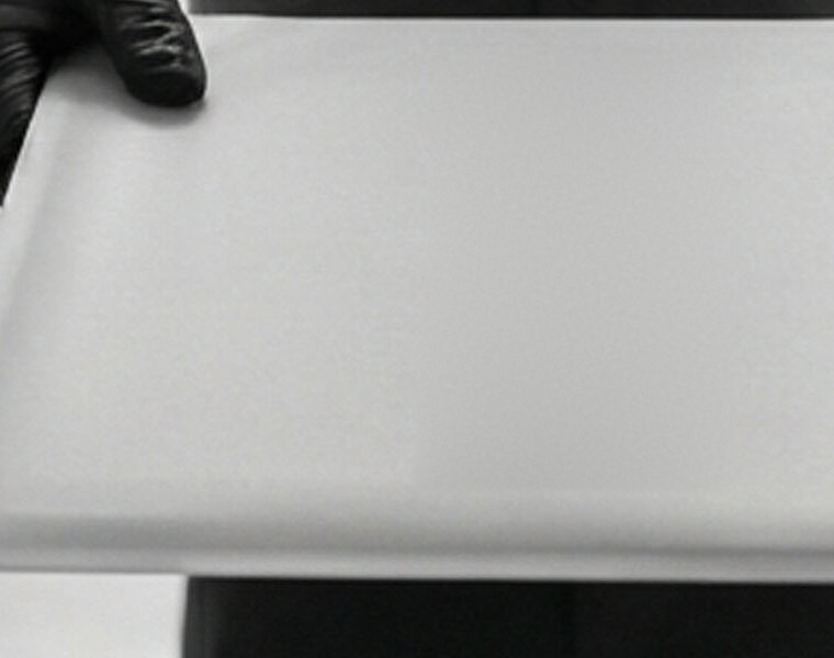A mailing envelope held in a gloved hand.